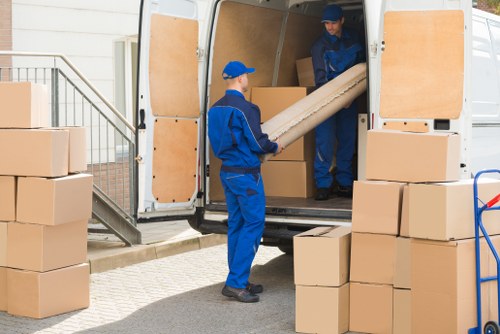 Removal team handling moving boxes and furniture in South Kensington
